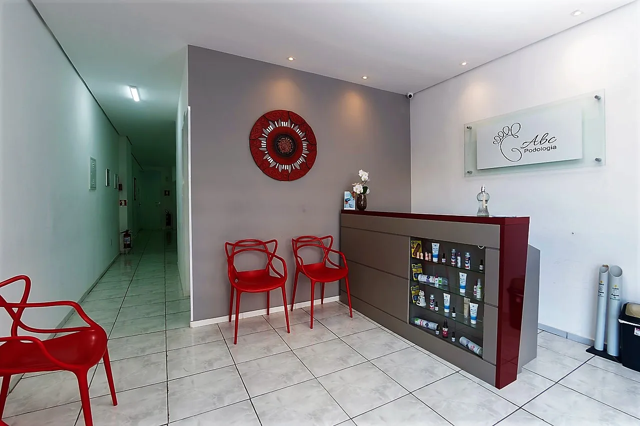 Recepção da Podologia ABC, com poltronas e a placa da clínica